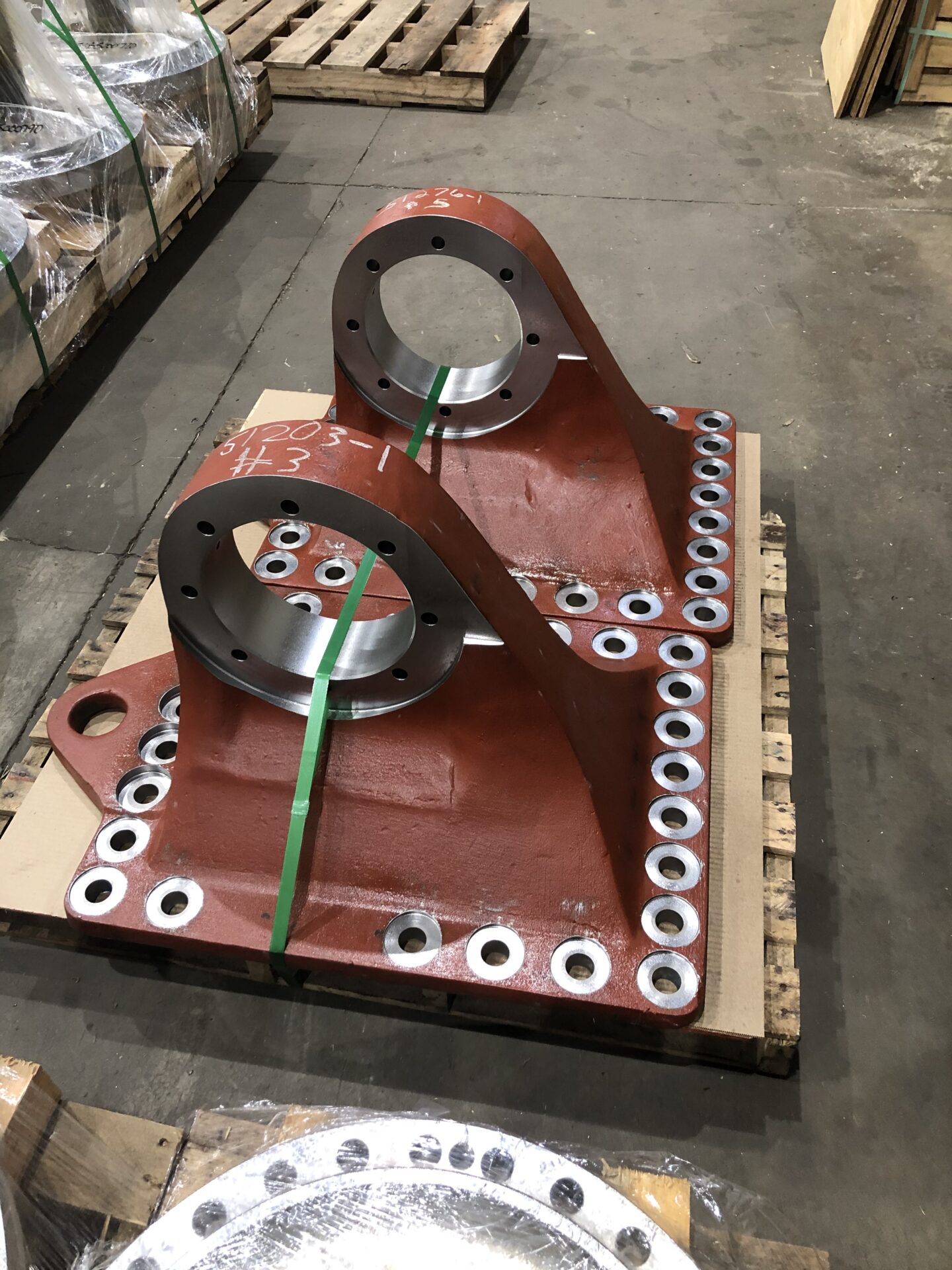A pair of large metal parts sitting on top of a pallet.