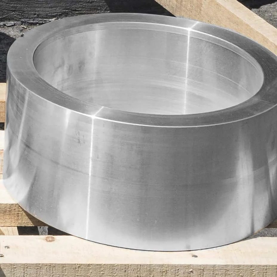 A large stainless steel bowl sitting on a pallet.