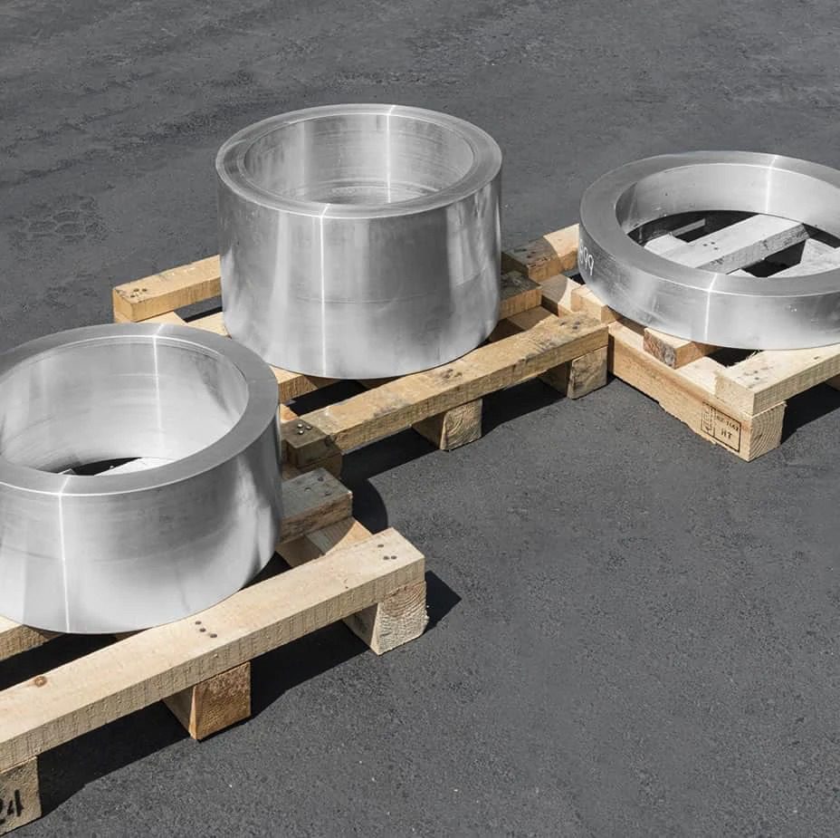 Three stainless steel cylinders sitting on pallets.