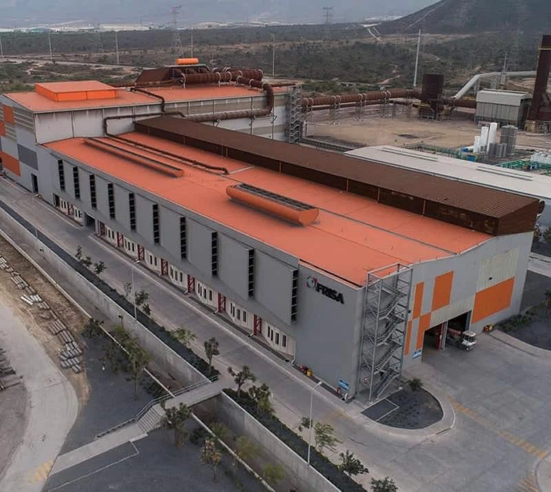 An aerial view of a large factory with orange roofs.