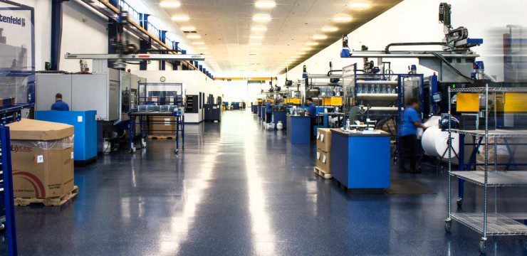 The inside of a factory with many machines and boxes.