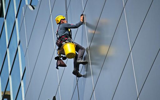 A man is climbing on the side of a building.