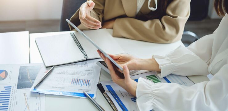 Two business people sitting at a table and talking to each other.