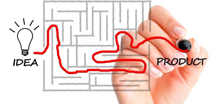 A hand drawing a maze with the words idea and product.