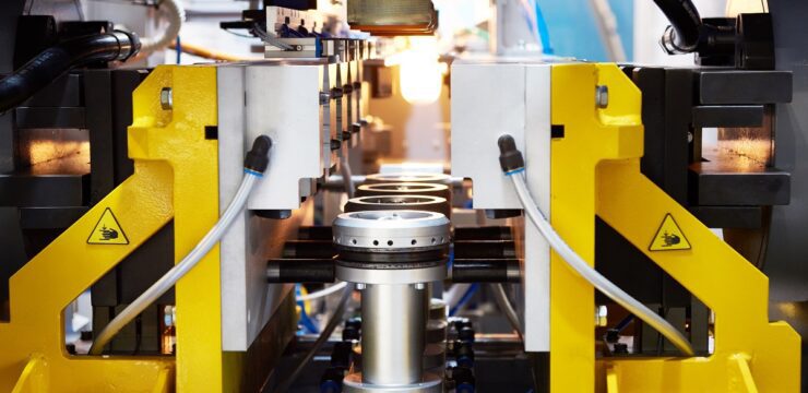 A machine in a factory that is making pipes.