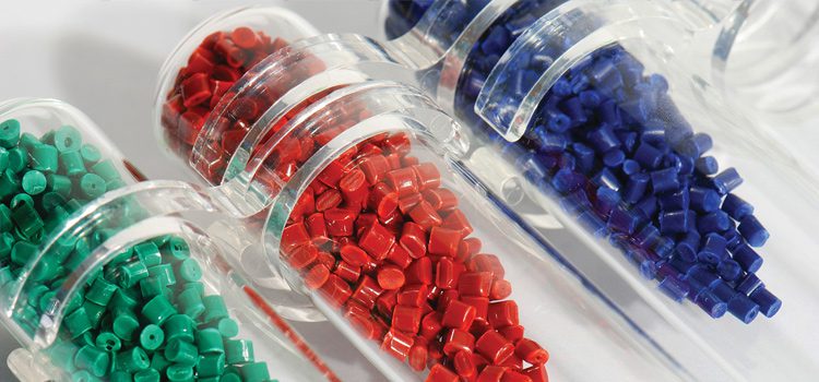 A variety of colored plastic pellets in a glass jar.