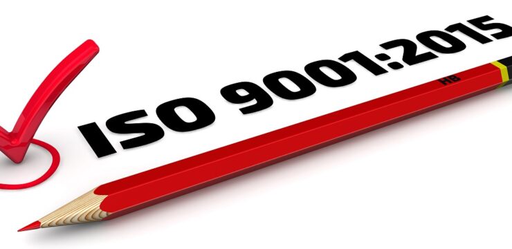 A red pencil with the word iso 9001 2015 on it.