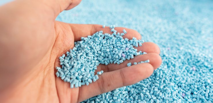 A person's hand holding a pile of blue sprinkles.