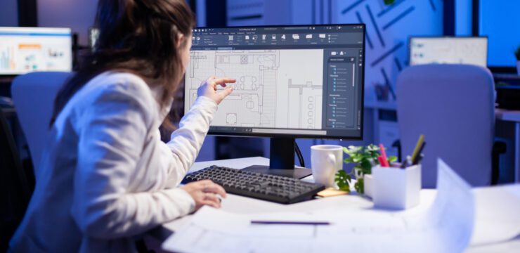 A woman is working on a computer in an office.