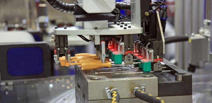 A machine is making plastic parts in a factory.