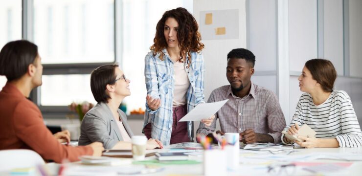 A group of people sitting around a table in an office.