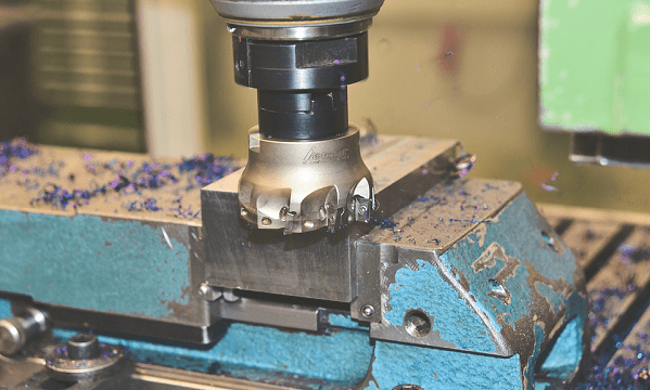 A cnc milling machine is working on a piece of metal.