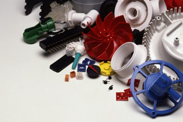 A variety of plastic parts are arranged on a white surface.