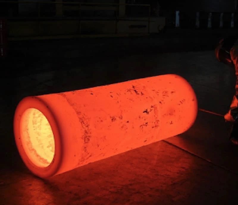 Glowing hot metal cylinder on floor.